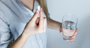 Woman taking pills with a glass of water