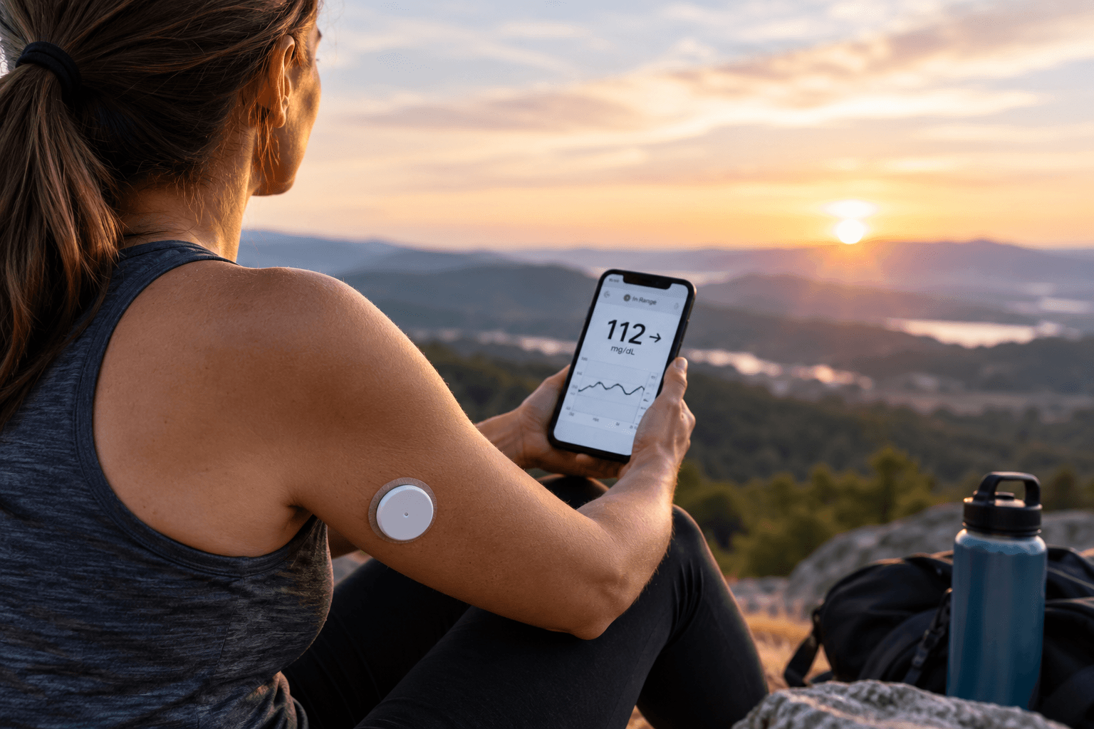 Person with type 1 diabetes using a continuous glucose monitor and smartphone to track glucose levels.