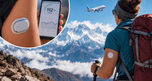 Person at high altitude wearing a continuous glucose monitor while checking glucose levels during low-oxygen conditions
