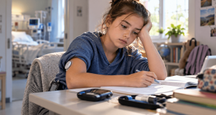 Young girl with type 1 diabetes wearing a continuous glucose monitor struggles to concentrate on homework, illustrating attention concerns associated with hypoglycemia and DKA.
